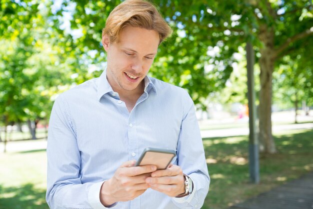 Nachdenkliche lächelnde simsende Mitteilung des Kerls am Telefon