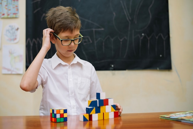 Kostenloses Foto nachdenklicher junge mit puzzle spielzeug