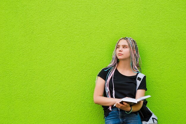 Nachdenklicher junger Student auf grün