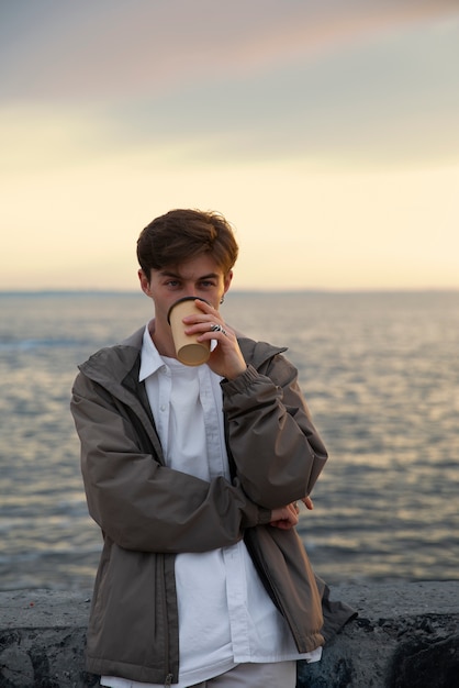 Kostenloses Foto nachdenklicher mann in mittlerer aufnahme am meer