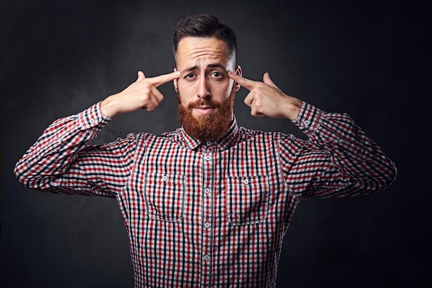 Nachdenklicher rothaariger bärtiger Hipster-Mann in einem roten Fleece-Shirt.