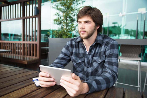 Nachdenklicher student, der tablette verwendet