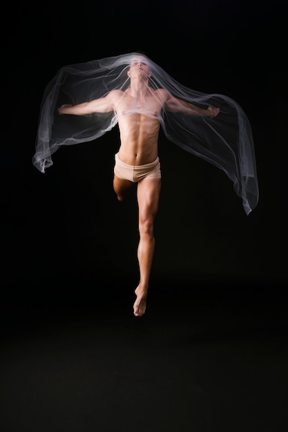 Kostenloses Foto nackter turner, der mit transparentem stoff springt