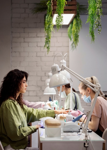 Kostenloses Foto nagelkunstfachmann, der an kundennägeln arbeitet