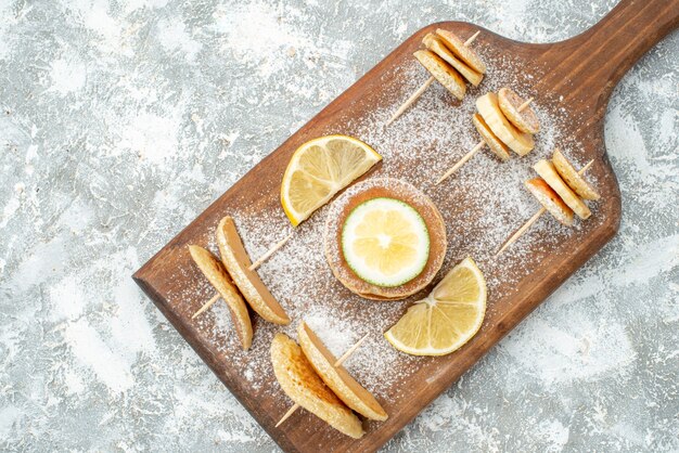 Nahansicht der klassischen Pfannkuchen mit Zitronen auf Holzschneidebrett auf Blau