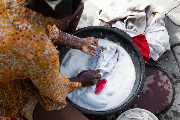 Kostenloses Foto nahaufnahme afrikanische frau, die kleidung wäscht