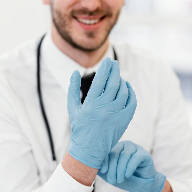 Nahaufnahme Arzt, der Handschuhe anzieht