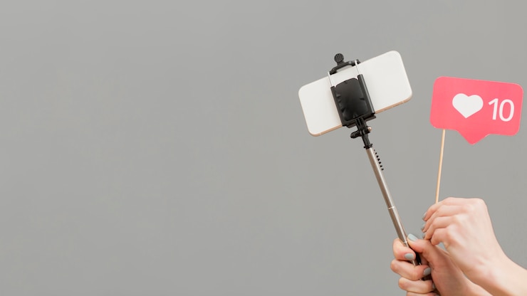 Kostenlose Foto nahaufnahme-blogger, der selfie-stock mit handy hält