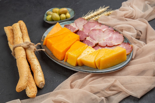 Nahaufnahme der besten leckeren Snacks für Wein auf einem Handtuch auf einem dunklen Tisch