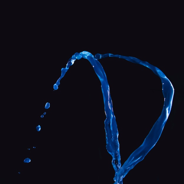 Nahaufnahme der blauen Flüssigkeit spritzend auf schwarzem Hintergrund