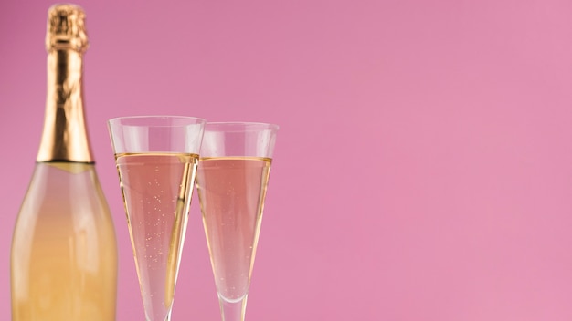 Nahaufnahme der Flasche Champagners mit Gläsern und Kopienraum