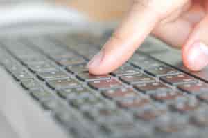 Kostenloses Foto nahaufnahme der geschäftsfrau hand tippen auf laptop-tastatur