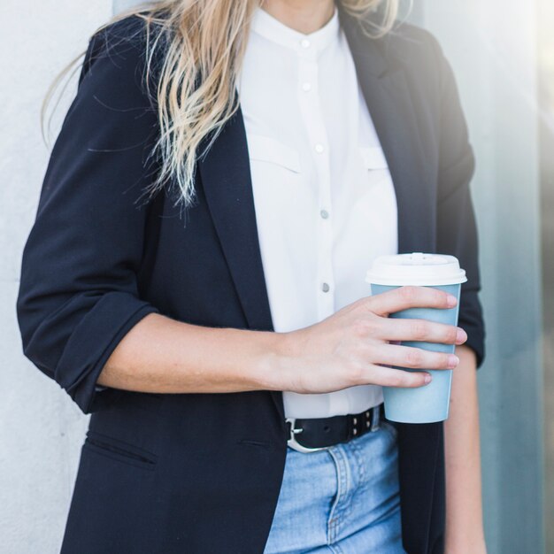 Nahaufnahme der Geschäftsfrau Wegwerfkaffeetasse in der Hand halten