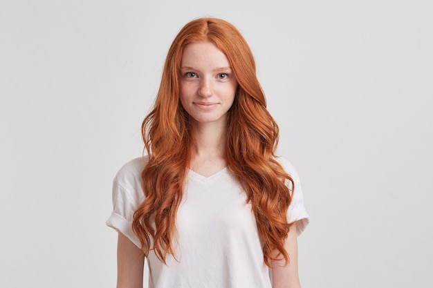 Kostenloses Foto nahaufnahme der glücklichen attraktiven jungen frau mit dem langen gewellten roten haar