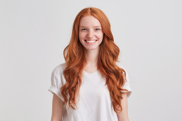 Kostenloses Foto nahaufnahme der glücklichen hübschen rothaarigen jungen frau mit dem langen gewellten haar