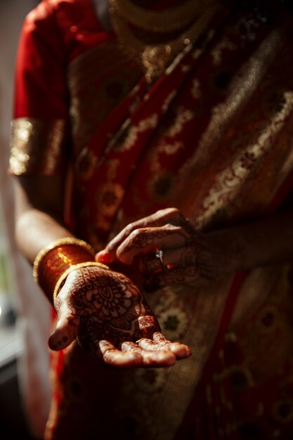 Nahaufnahme der Hände der hindischen Braut bedeckt mit Hennastrauchtätowierungen