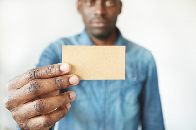 Nahaufnahme der Hände des afrikanischen Mannes, die Visitenkarte halten