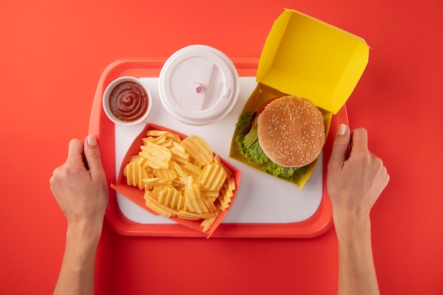 Nahaufnahme der Hände, die ein Tablett mit Essen halten