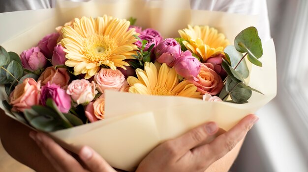 Nahaufnahme der Hände, die Geburtstagsblumen halten