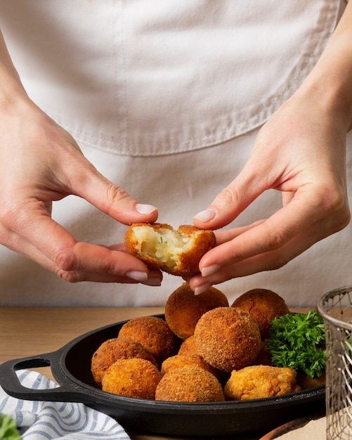 Nahaufnahme der Hände, die Lebensmittelkrokette halten