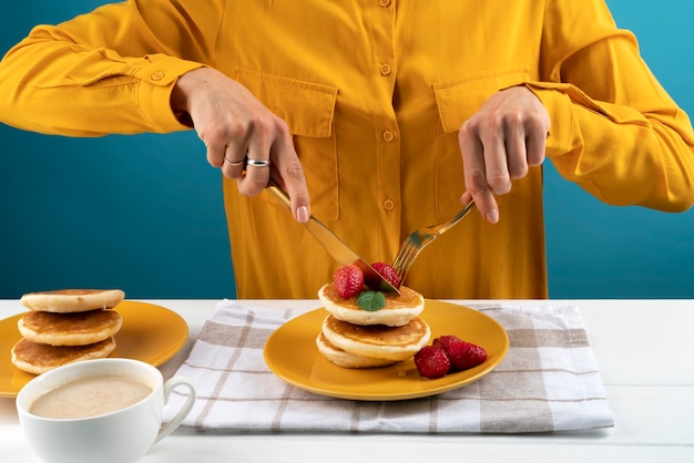 Nahaufnahme der Hände, die Pfannkuchen schneiden