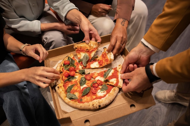 Nahaufnahme der Hände, die Pizzascheiben halten