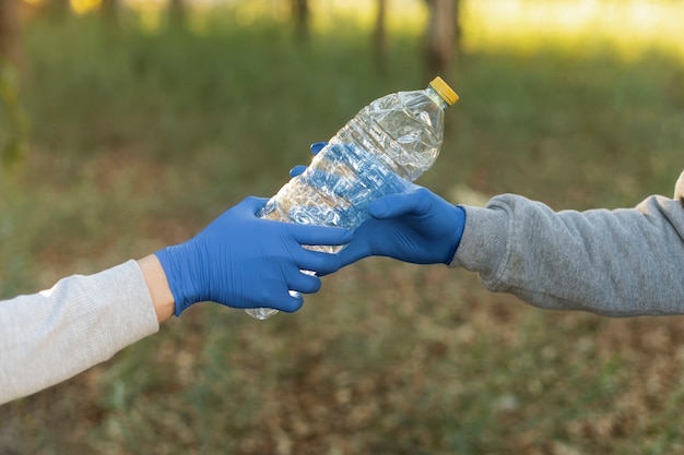 Kostenloses Foto nahaufnahme der hände, die plastikflasche halten
