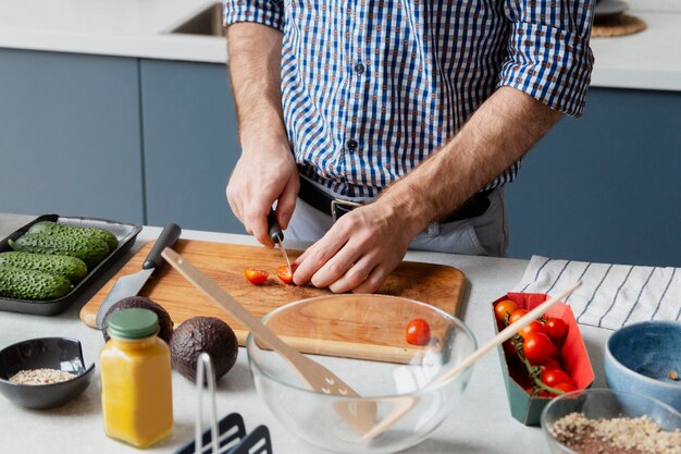 Nahaufnahme der Hände, die Tomaten schneiden