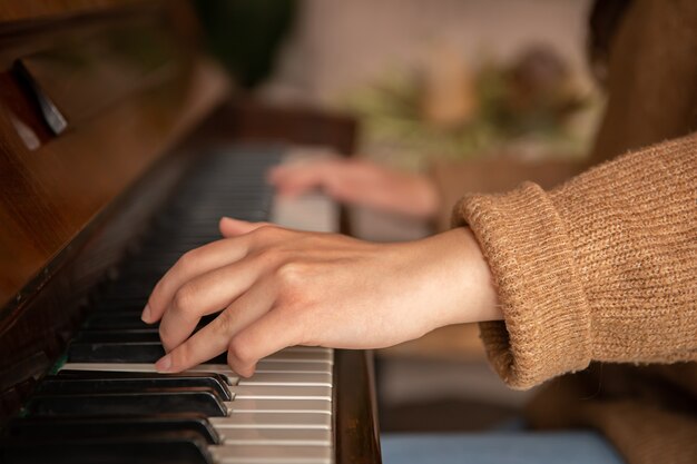 Nahaufnahme der Hände eines Pianisten auf den Klaviertasten, weibliche Hände, die das Klavier spielen.