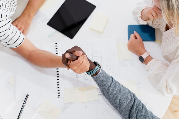 Nahaufnahme der Hände junger Kollegen in einem Meeting