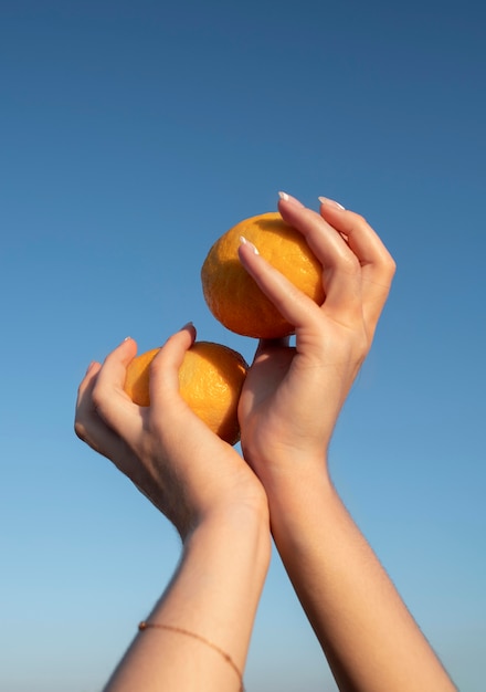 Nahaufnahme der Hände mit Orangen