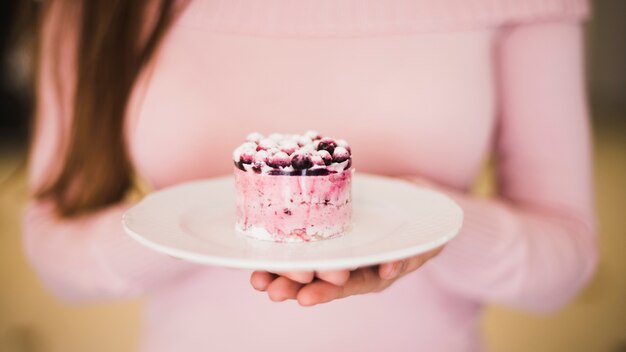 Nahaufnahme der Hand blauen Beerenkuchen auf weißer Platte halten