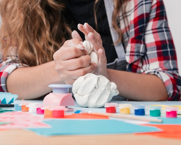 Nahaufnahme der Hand der jungen Frau weißen Lehm knetend