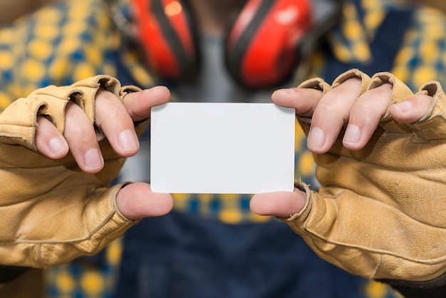 Nahaufnahme der Hand des Heimwerkers Schutzhandschuhe zeigend, die Visitenkarte zeigen