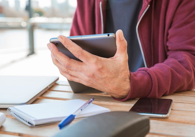 Nahaufnahme der Hand des Mannes digitale Tablette in der Hand an draußen caf� halten