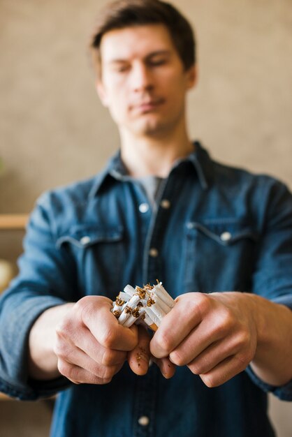 Nahaufnahme der Hand des Mannes gebrochenes Bündel Zigaretten