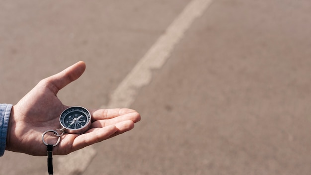 Nahaufnahme der Hand des Mannes Navigationskompass auf Straße halten