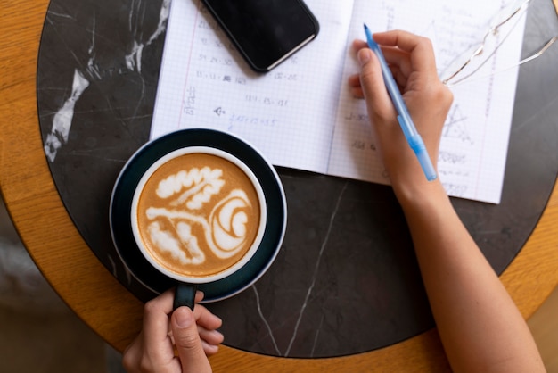 Nahaufnahme der Hand, die eine köstliche Kaffeetasse hält