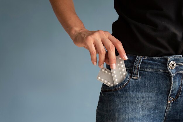 Nahaufnahme der Hand, die Tablettenfolie in die Tasche steckt