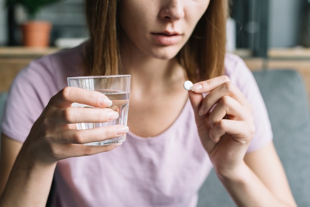 Nahaufnahme der Hand einer Frau, die Medizin einnimmt