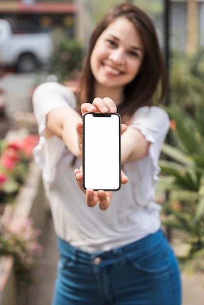 Nahaufnahme der Hand einer Frau, die Smartphone mit leerem weißem Bildschirm hält