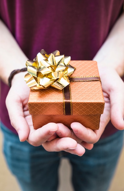 Nahaufnahme der Hand eines Mannes, die Valentinsgrußgeschenk hält