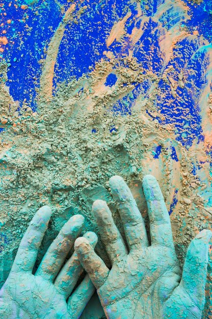 Nahaufnahme der Hand gemalt mit holi Farbpulver auf blauem Hintergrund