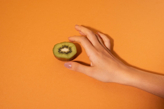 Nahaufnahme der Hand mit Kiwi