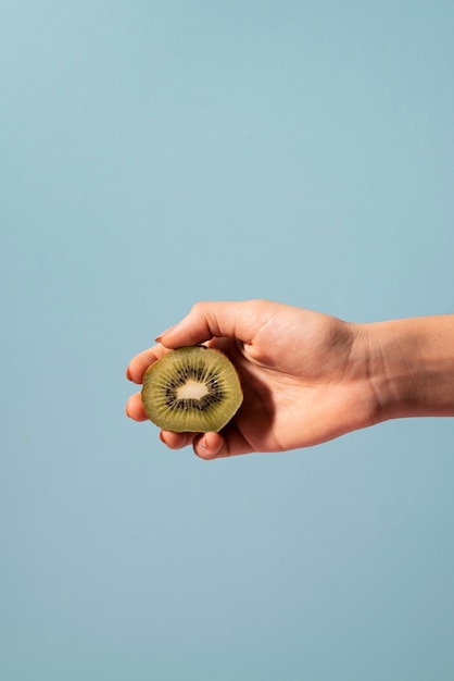 Nahaufnahme der Hand mit Kiwi