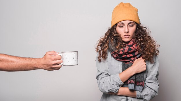 Nahaufnahme der Handkaffee der kranken Frau anbietend, die Kälte und Grippe hat