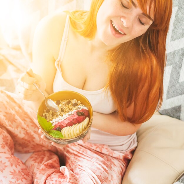 Nahaufnahme der jungen Frau das Hafermehlfrühstück genießend