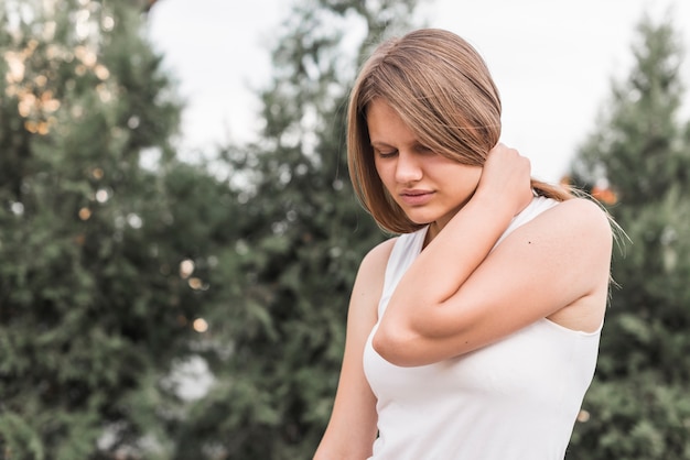 Nahaufnahme der jungen Frau, die Nackenschmerzen hat