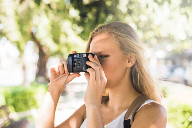 Nahaufnahme der jungen Frau fotografierend mit moderner Digitalkamera