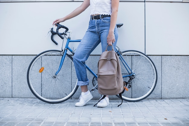 Kostenloses Foto nahaufnahme der jungen frau mit ihrem rucksack, der nahe dem fahrrad steht